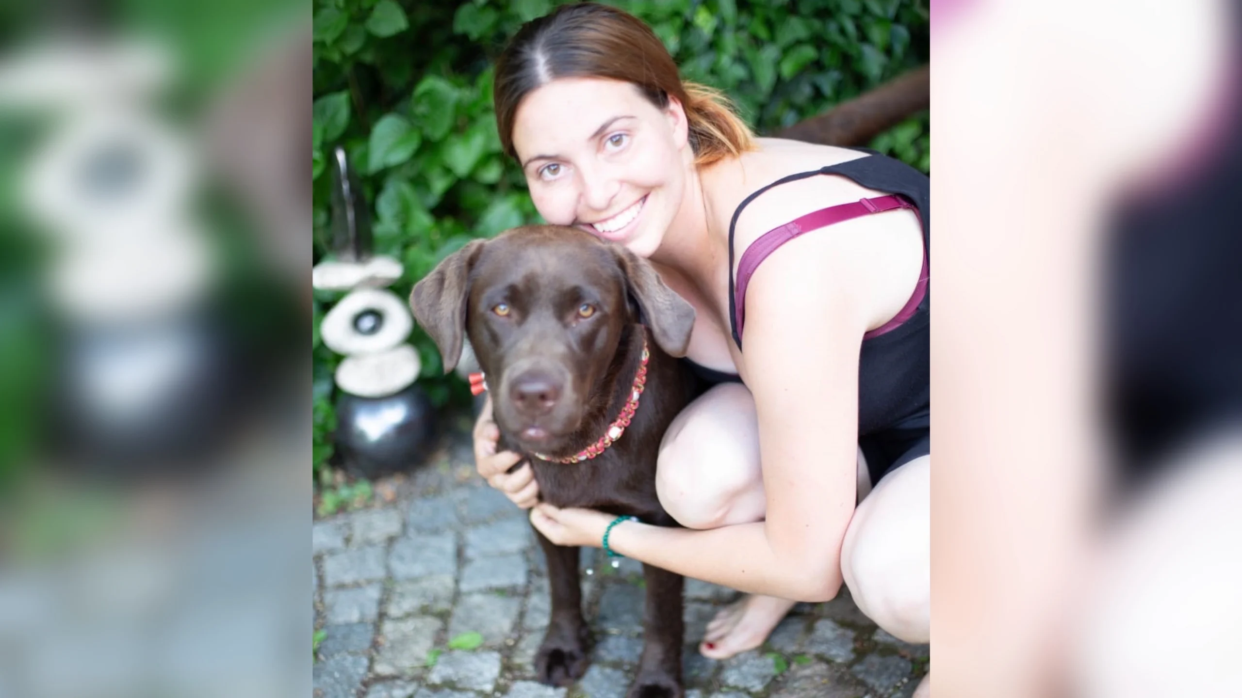 Lächelnde Frau umarmt Hund.
