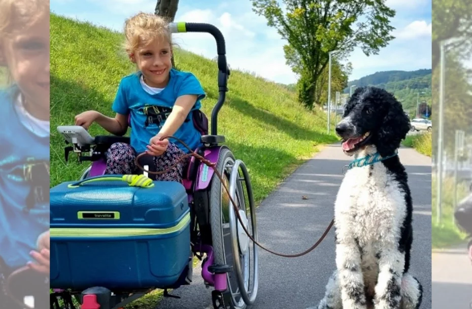 Mädchen im Rollstuhl hält Hund an der Leine.