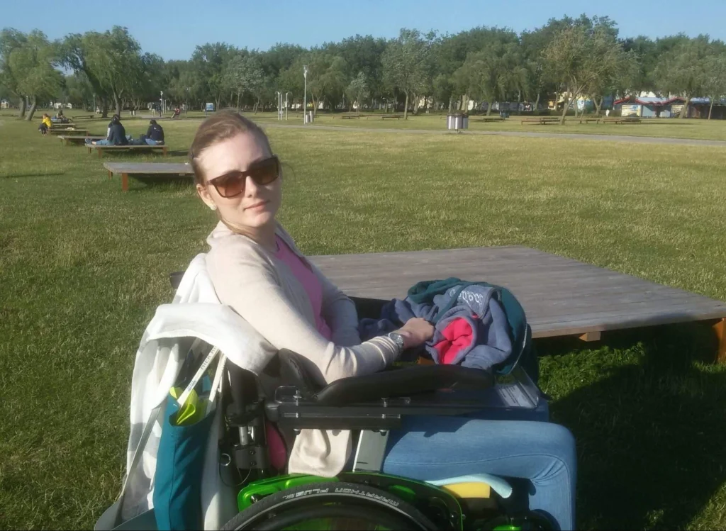 Frau in Rollstuhl im Park.